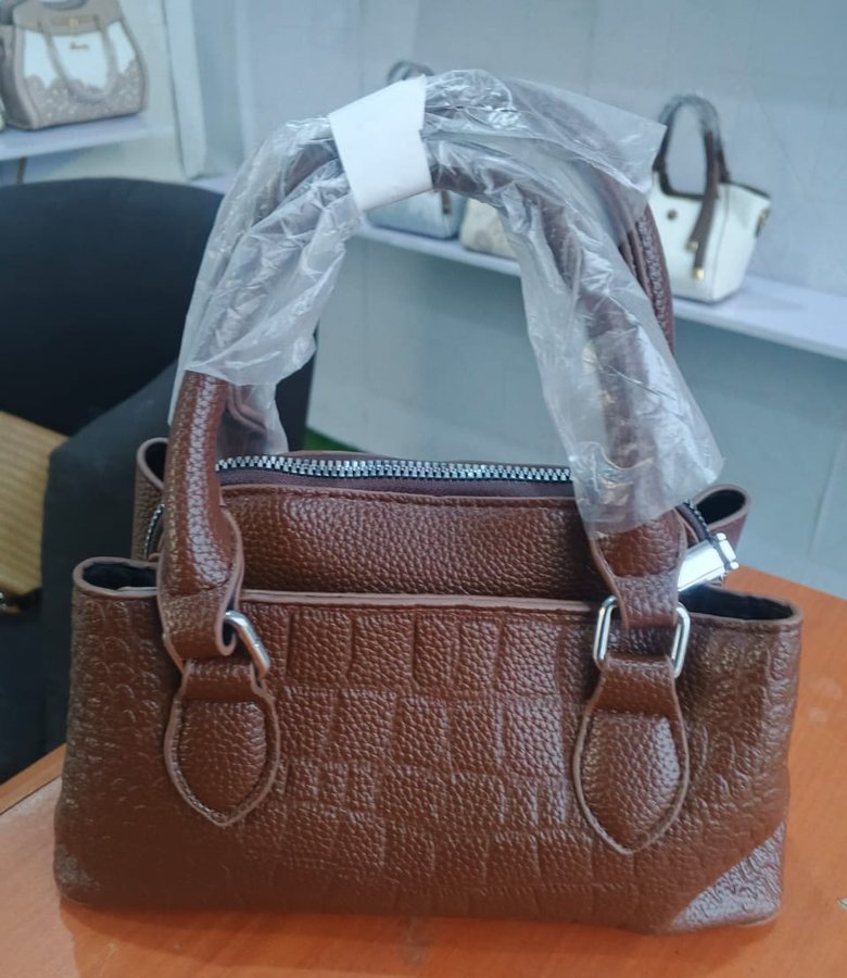 Tan croc-embossed barrel bag